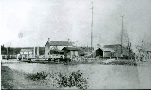 Not far from the traffic of U.S. Route 1 in Lawrence Township lies the site of another historic community with ties to the Delaware and Raritan Canal.  Baker’s Basin was settled before the canal was constructed, with the building of a hotel by Benjamin Baker in 1806.  Over the ensuing years, a store, grange hall, coal yard, mule shed, school house and 10 dwellings were constructed around a canal basin, which was used to load and discharge cargo.  Ice from the nearby Howell’s Mill was stored in large ice houses and used to refrigerate canal boat cargos, as well as for delivery to area homes. 